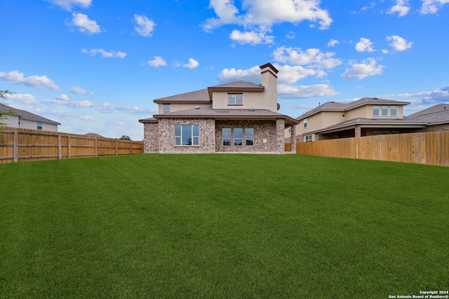 rear view of house with a yard