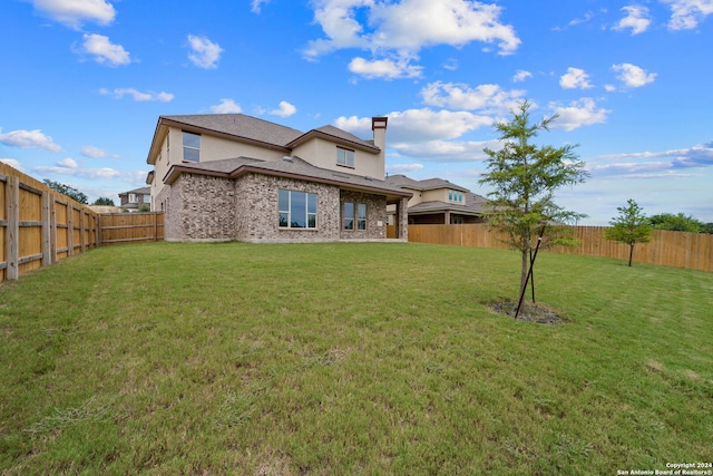 rear view of property featuring a yard