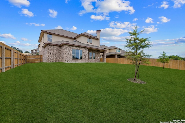 rear view of property featuring a yard