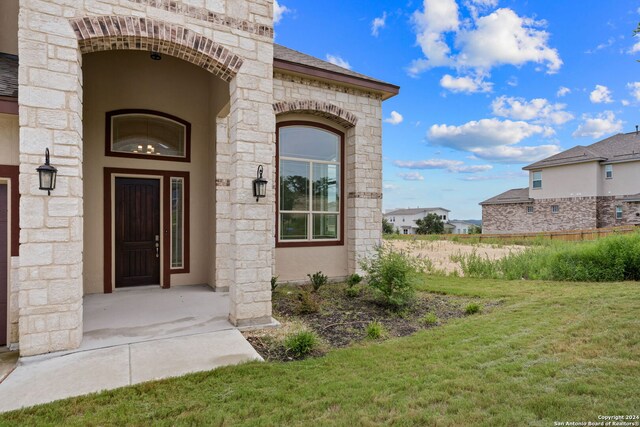 doorway to property with a lawn