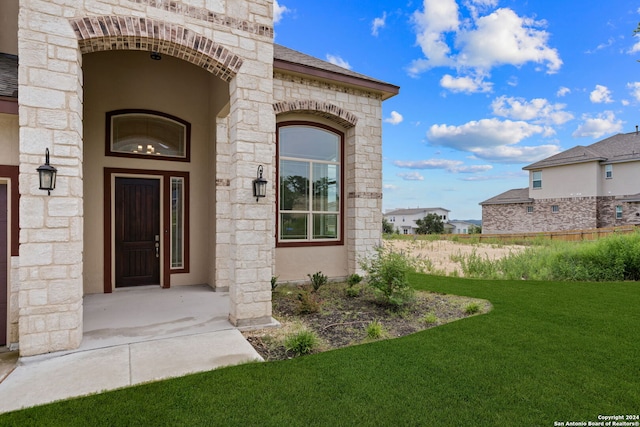 entrance to property with a lawn