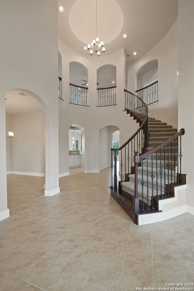 foyer featuring ceiling fan with notable chandelier and light tile patterned floors