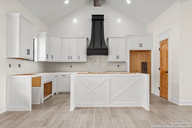 kitchen featuring white cabinets, premium range hood, and light wood-type flooring