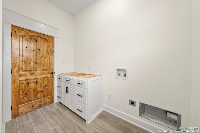 clothes washing area with cabinets, light hardwood / wood-style flooring, electric dryer hookup, and washer hookup