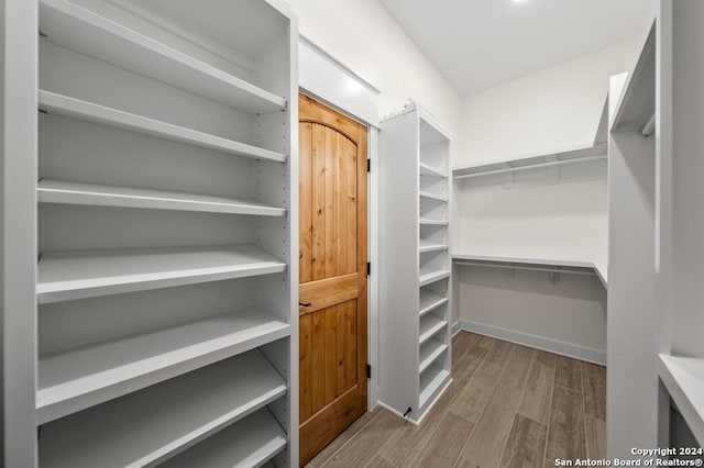 spacious closet with light hardwood / wood-style flooring