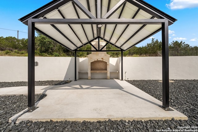 view of patio with a gazebo and exterior fireplace