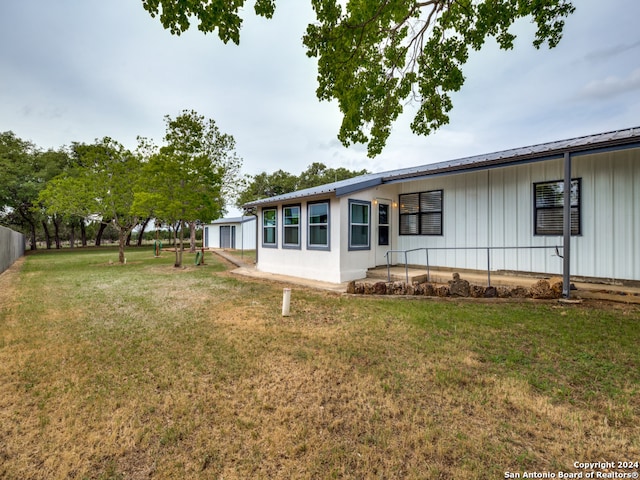 rear view of house featuring a yard