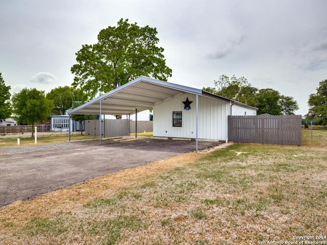 view of parking / parking lot with a yard and a carport