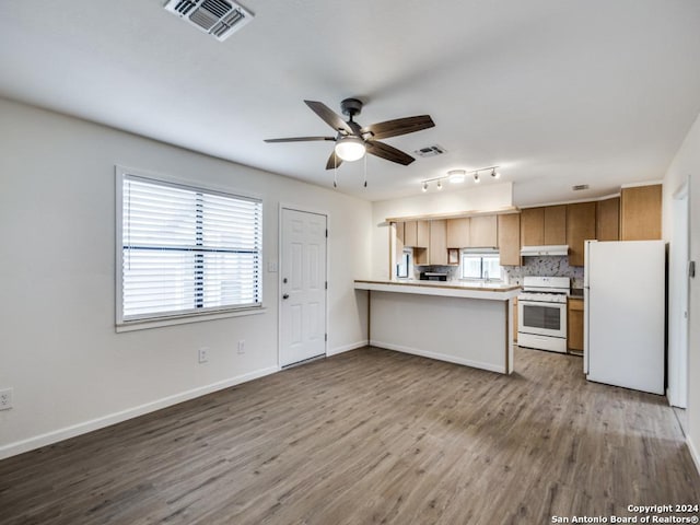 kitchen with decorative backsplash, white appliances, ceiling fan, kitchen peninsula, and light wood-type flooring