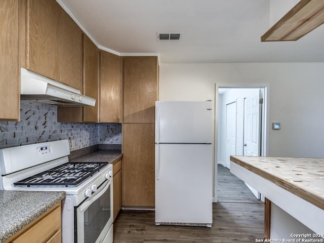 kitchen with tasteful backsplash, white appliances, and dark wood-type flooring