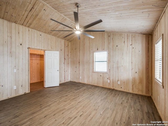 unfurnished bedroom featuring wood walls, wood-type flooring, vaulted ceiling, and wooden ceiling