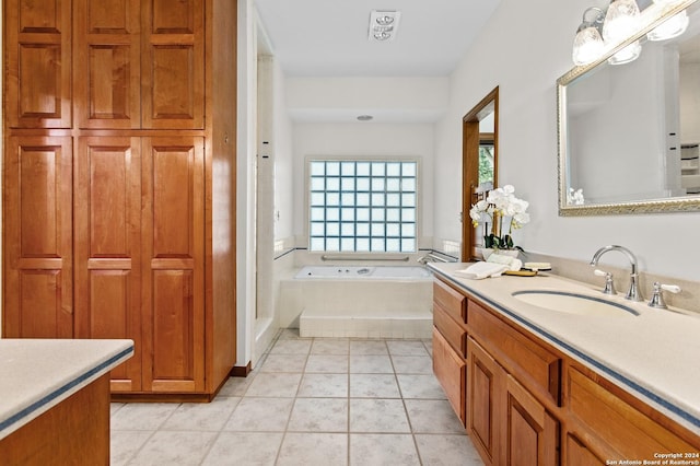 bathroom with tile patterned flooring, vanity, and a bath