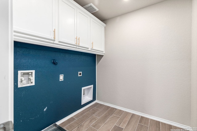 clothes washing area with washer hookup, light hardwood / wood-style flooring, cabinets, and hookup for an electric dryer