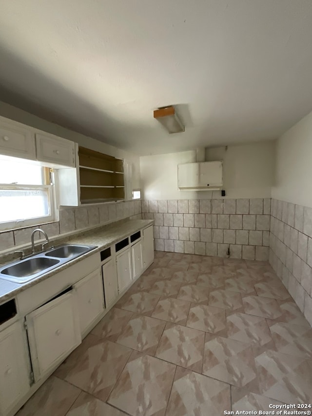 kitchen with sink, light tile patterned flooring, tasteful backsplash, and white cabinets