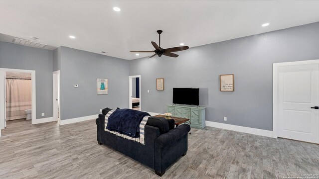 living room with light hardwood / wood-style flooring and ceiling fan