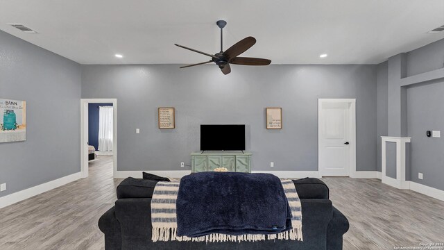 living room with light hardwood / wood-style floors and ceiling fan