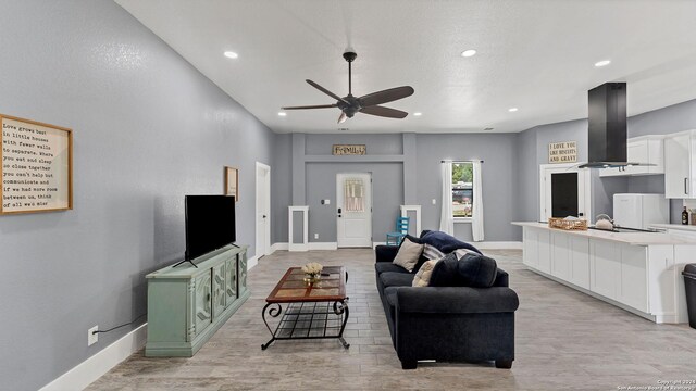 living room featuring light hardwood / wood-style flooring and ceiling fan