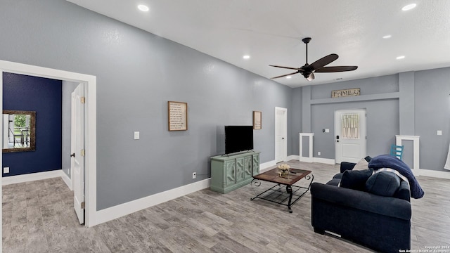 living room with ceiling fan and light wood-type flooring