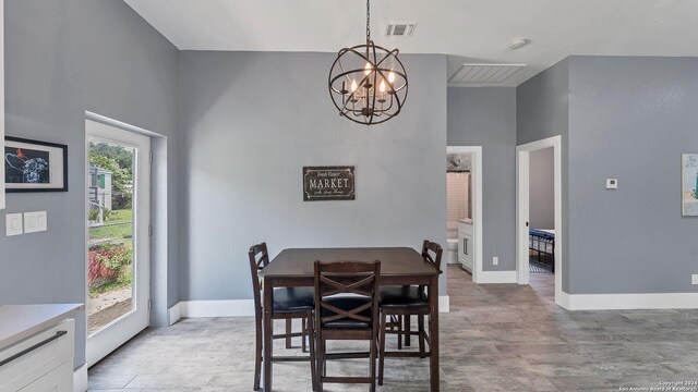 dining room with a high ceiling, a chandelier, and hardwood / wood-style floors