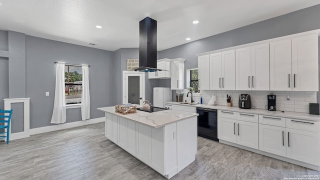 kitchen featuring white cabinetry, plenty of natural light, a center island with sink, and wall chimney exhaust hood