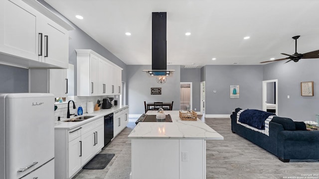 kitchen with tasteful backsplash, light stone counters, ceiling fan, white refrigerator, and sink