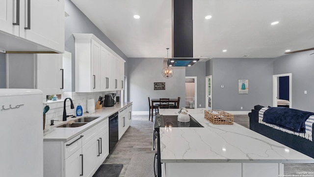 kitchen with sink, white cabinetry, light stone counters, a center island, and black dishwasher