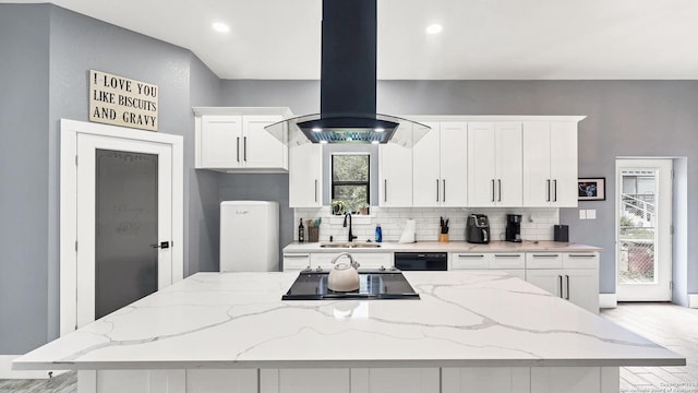 kitchen with island range hood, black appliances, light stone countertops, white cabinets, and decorative backsplash