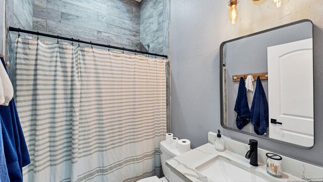 bathroom featuring vanity, curtained shower, and toilet