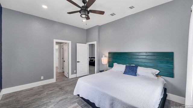 bedroom featuring ceiling fan, hardwood / wood-style floors, and a towering ceiling