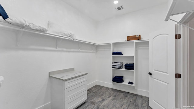 spacious closet with dark hardwood / wood-style flooring