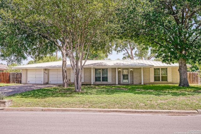 single story home with a garage and a front lawn