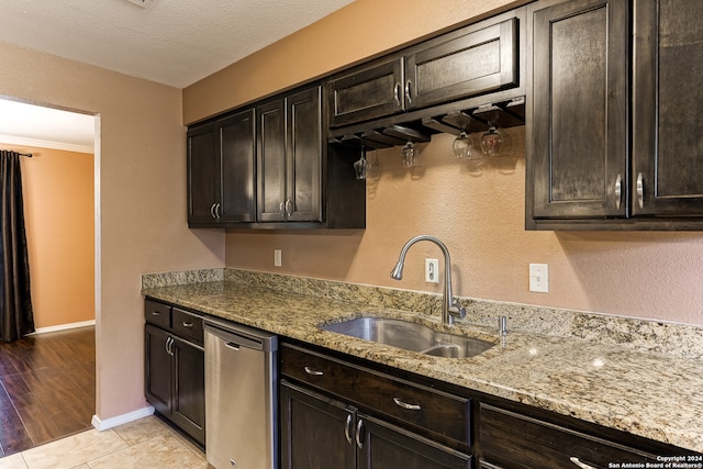 kitchen featuring light hardwood / wood-style floors, light stone counters, sink, and stainless steel dishwasher