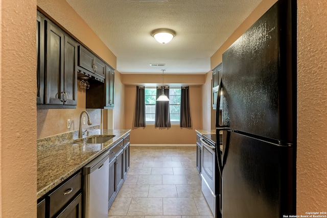 kitchen featuring dishwashing machine, black refrigerator, sink, stove, and light tile patterned floors