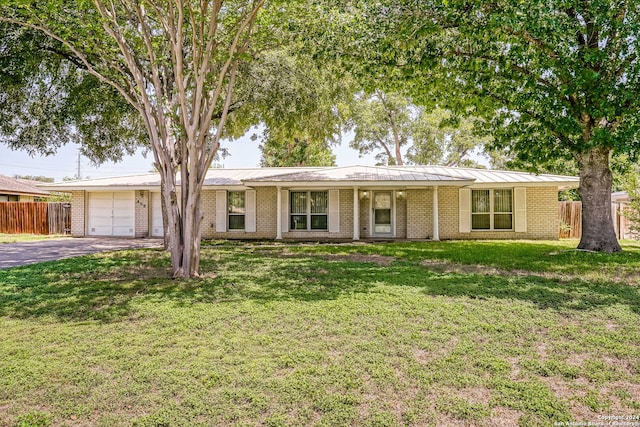 single story home featuring a garage and a front yard