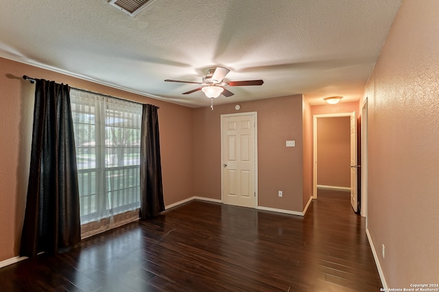 empty room with a textured ceiling, ceiling fan, and dark wood-type flooring