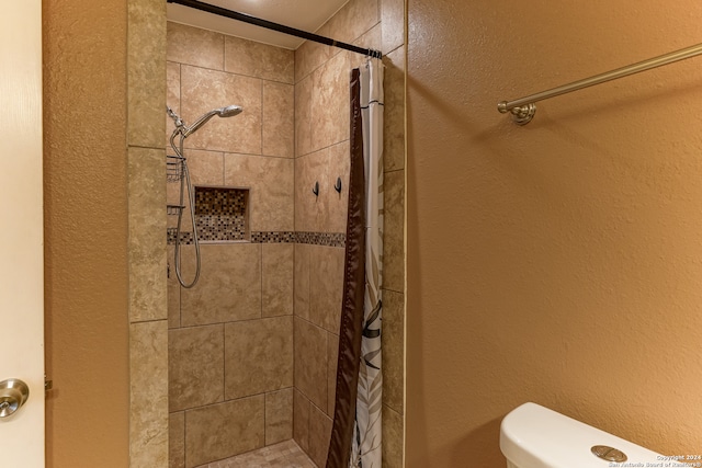 bathroom with a shower with shower curtain and toilet