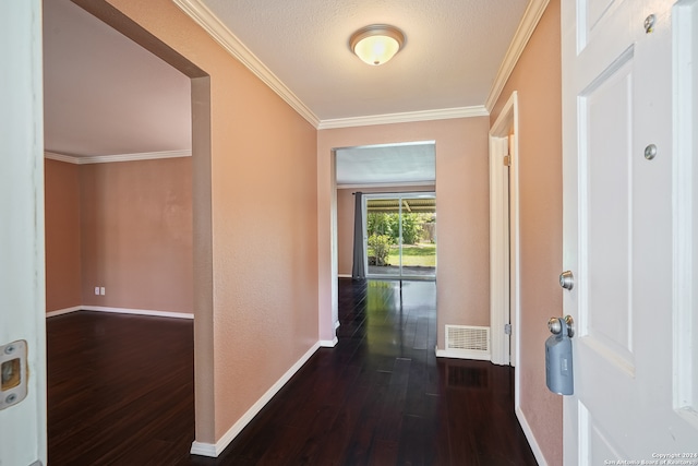 corridor featuring dark wood-type flooring, a textured ceiling, and ornamental molding