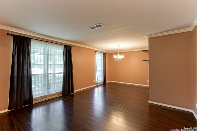 spare room featuring dark hardwood / wood-style floors, crown molding, and a chandelier