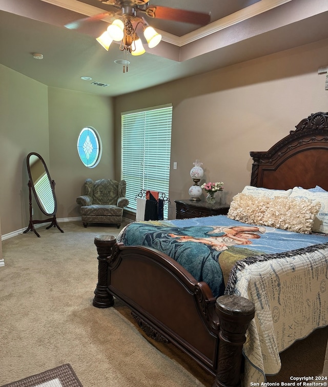 bedroom with carpet flooring, a tray ceiling, and ceiling fan