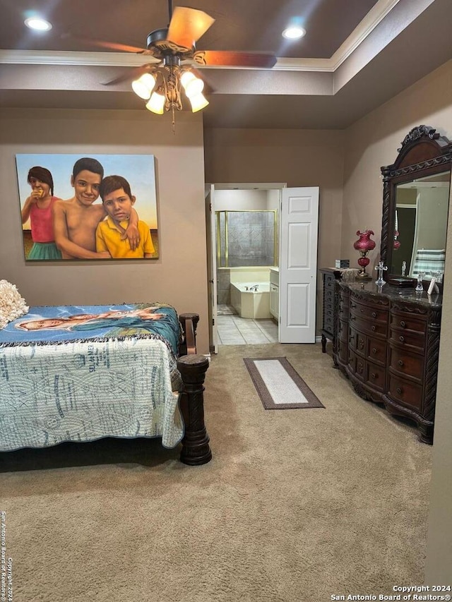 bedroom with a raised ceiling, ensuite bath, light tile patterned floors, and ceiling fan