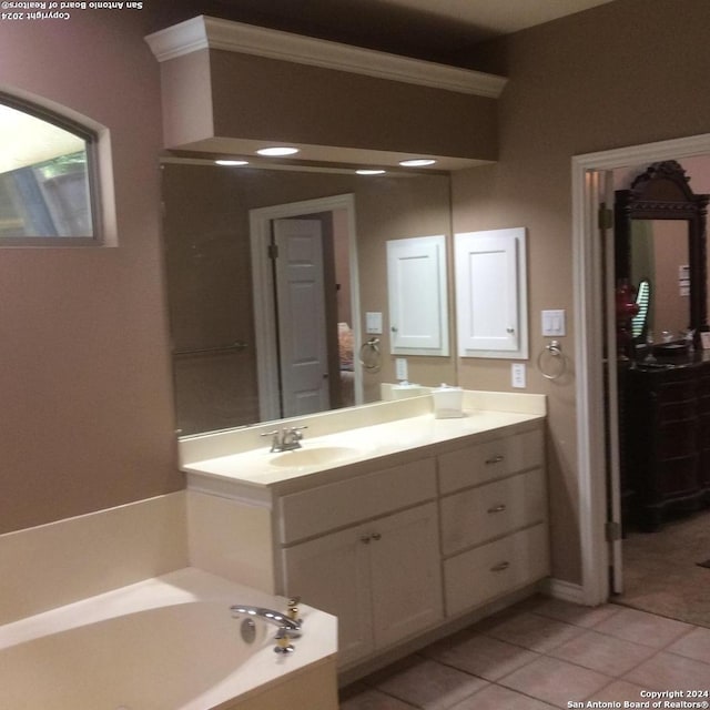 bathroom with tile patterned flooring, a bathing tub, and vanity