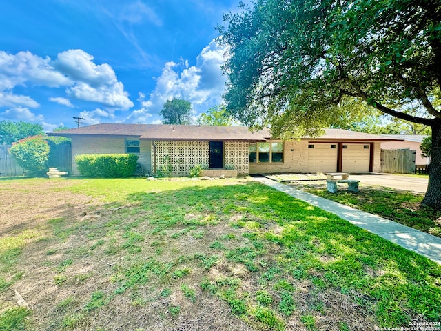 ranch-style house featuring a garage and a front yard