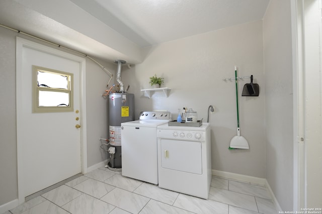 clothes washing area with gas water heater, washing machine and dryer, and light tile patterned floors