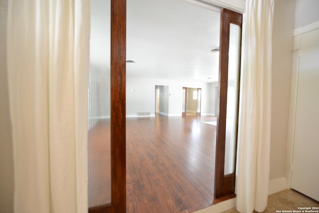 hallway with hardwood / wood-style flooring