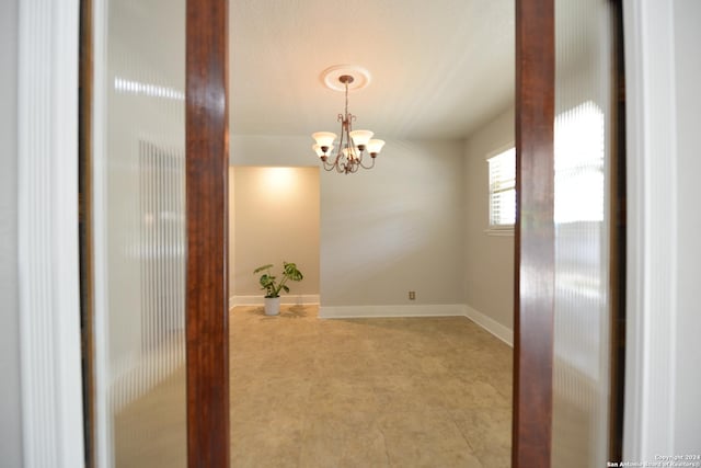 empty room featuring a notable chandelier