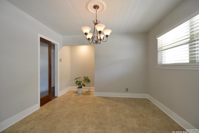 spare room with an inviting chandelier