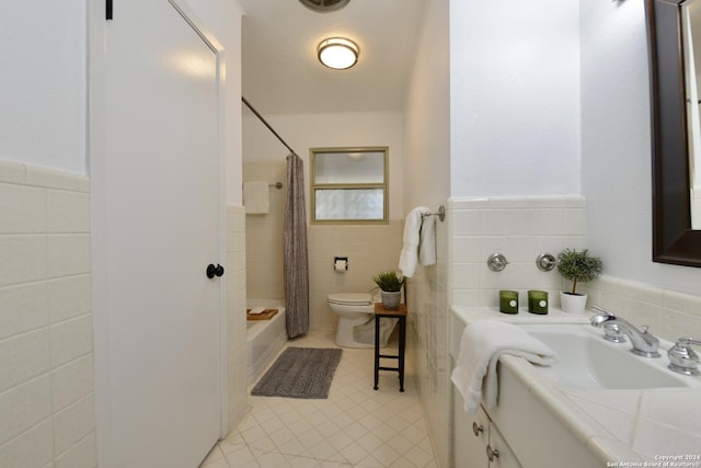 full bathroom featuring shower / tub combo with curtain, tile walls, vanity, toilet, and tile patterned floors