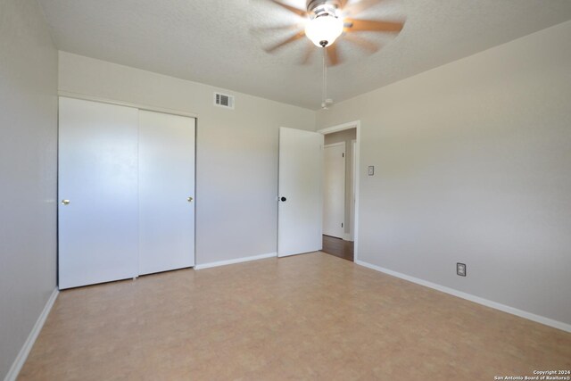 unfurnished bedroom with a closet, a textured ceiling, and ceiling fan