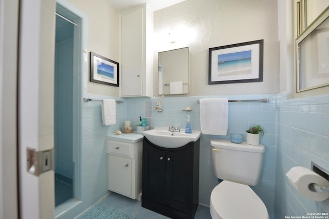 bathroom featuring vanity, tile patterned floors, tile walls, and toilet