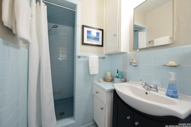 bathroom featuring vanity, curtained shower, and tile walls